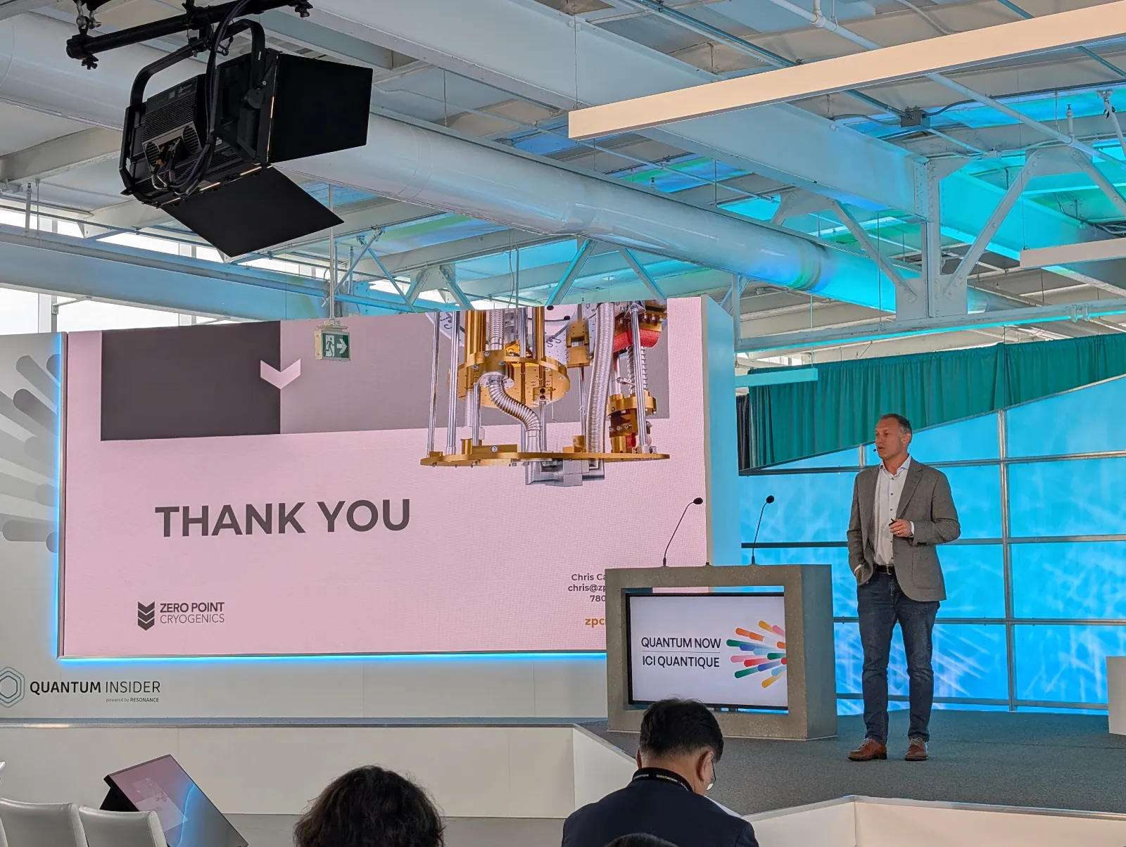 Zero Point Cryogenics CEO Chris Cassin presenting on stage at Quantum Now 2025, with a slide showing cryogenic equipment and a thank-you message.